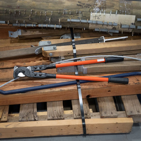 An application photo showing the 63041 25-inch standard cable cutter resting on a wooden pallet next to electrical wire and materials, demonstrating its portability and industrial structural integrity on a jobsite.
