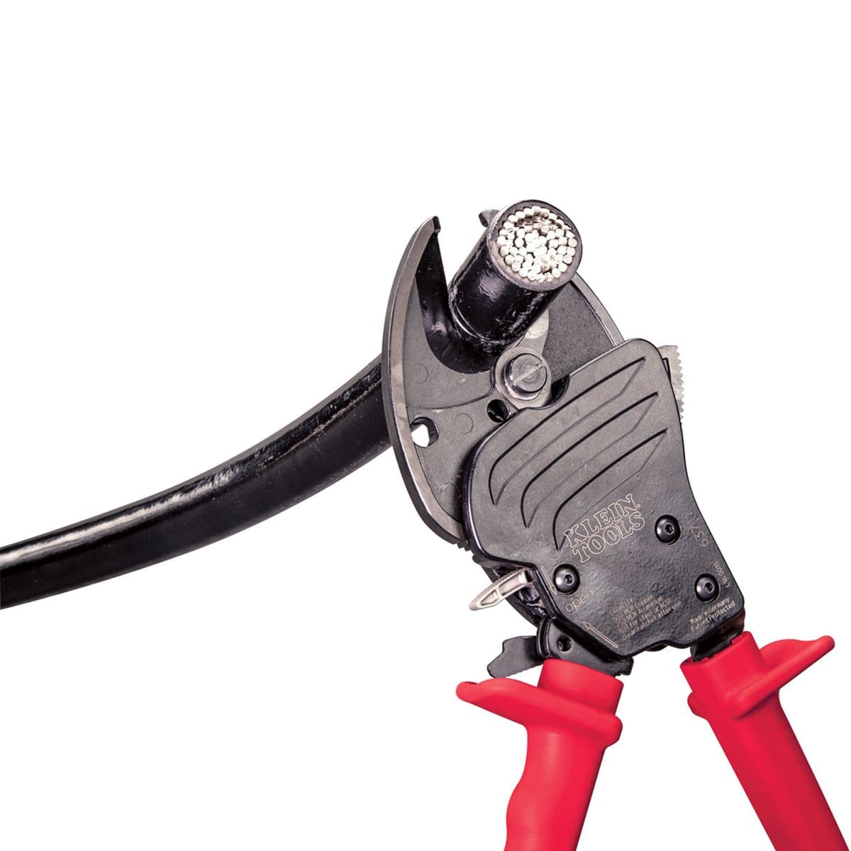 A close-up application shot of the open-jaw blades engaging a thick black insulated cable, illustrating the precision-ground hardened steel cutting edges and the mechanical advantage of the ratcheting system.
