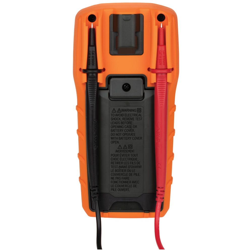 Rear view of the Klein Tools MM320 multimeter illustrating the built-in test lead storage. The red and black right-angle probes are securely clipped into the back of the orange protective holster for organized transport and storage.