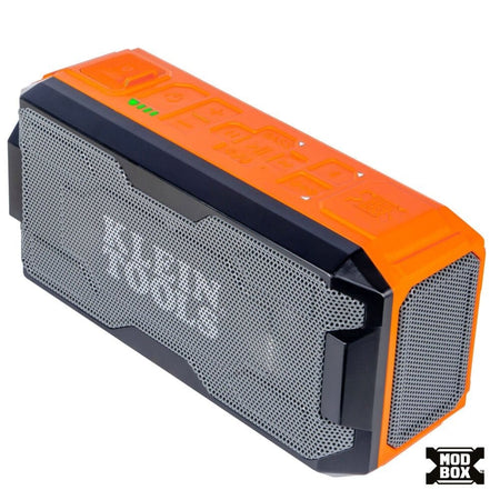 Angled studio view of the Klein Tools MODbox Bluetooth Speaker featuring a rugged orange and black housing with a grey mesh front grille.