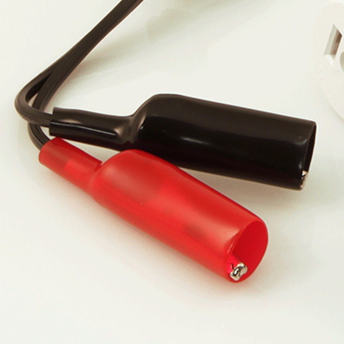 Close-up perspective of the red and black alligator clip leads from the 69411 kit. The image showcases the thick, protective insulation on the clips and the flexible black wiring, designed to provide a secure and safe connection to bare electrical wires or terminal blocks.