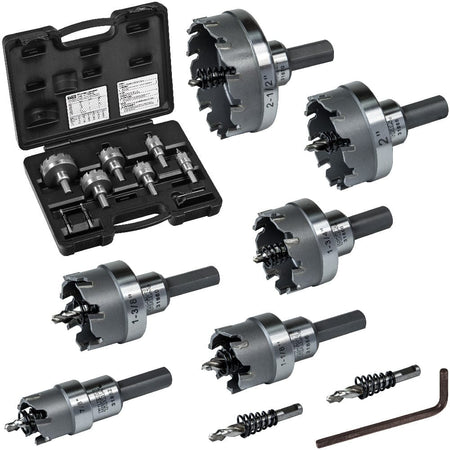 The image shows a set of metal hole saws and drill bits arranged on a white surface, with a black plastic carrying case open on the left.  The hole saws are circular with serrated edges and various sizes, each attached to a cylindrical shaft.  Two drill bits and a small metal tool are also visible at the bottom right.  The image is framed within a black border.
