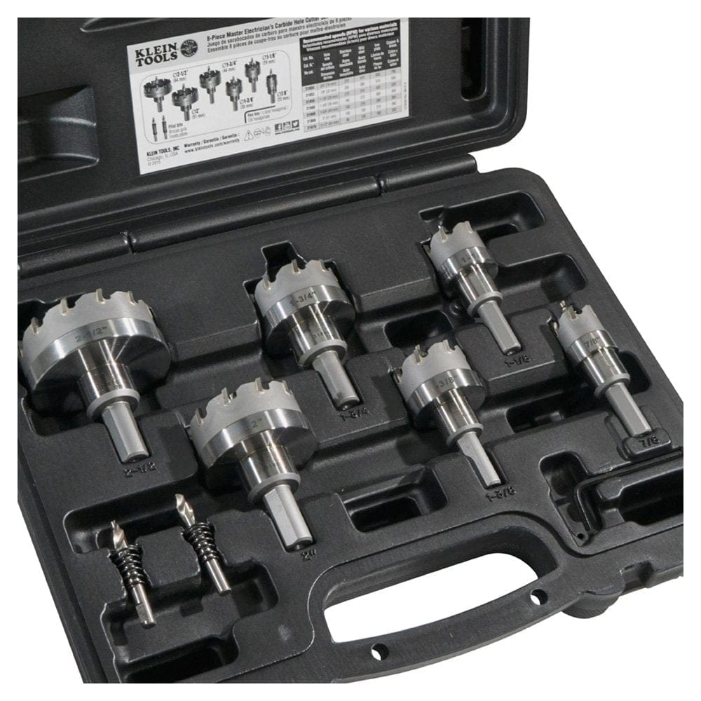 The open Klein 8-piece carbide hole cutter kit, showing all six cutters and two extra pilot bits organized in their molded spots.