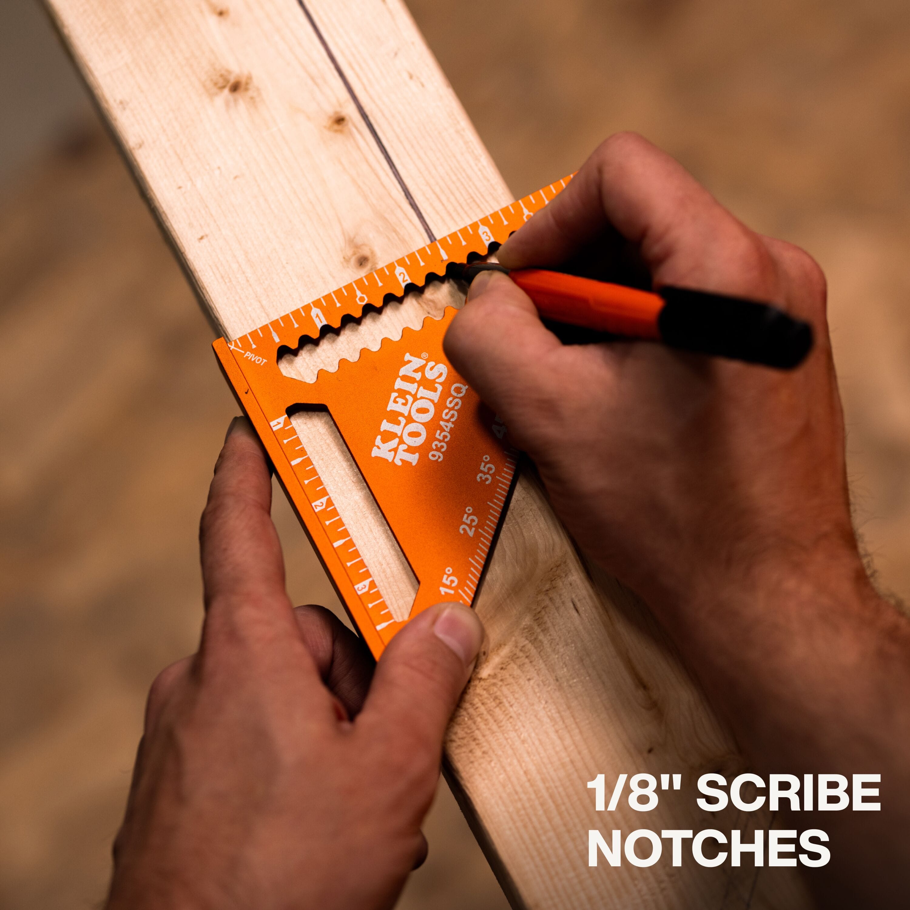 A close-up demonstration of the built-in 1/8-inch scribe notches, showing a carpenter using a pencil and the square to draw a perfectly straight, consistent line along a piece of lumber for precision woodworking.