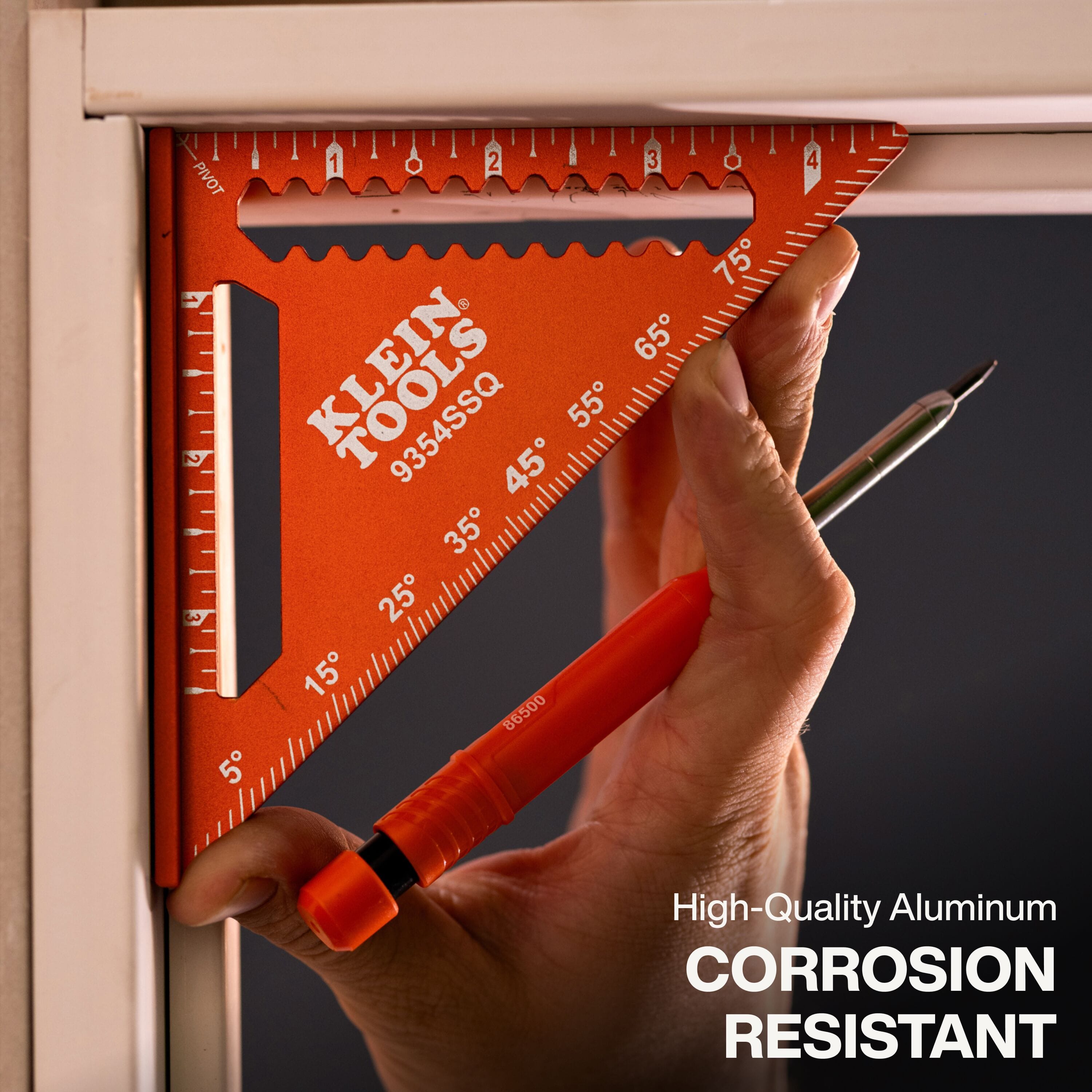 A functional demonstration of the corrosion-resistant orange trim square being used as a reference guide for aligning a door frame, highlighting its high-quality aluminum construction and dual-reference base for professional layout work.
