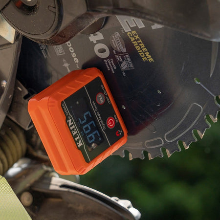 The digital angle gauge attached to a tilted saw blade, displaying an angle of 59.5 degrees with the display text rotated for easy reading.