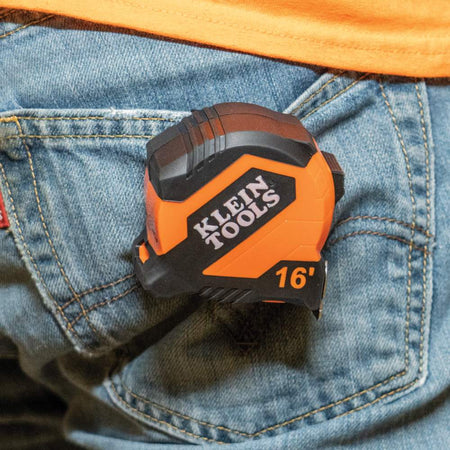 A worker carrying the compact Klein Tools 16-foot tape measure clipped conveniently to their jeans pocket for quick access.