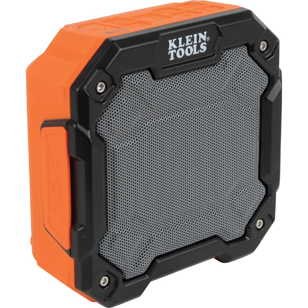 Angled front view of the rugged Klein Tools AEPJS3 portable Bluetooth jobsite speaker showing the heavy-duty orange and black housing and metal speaker grill.
