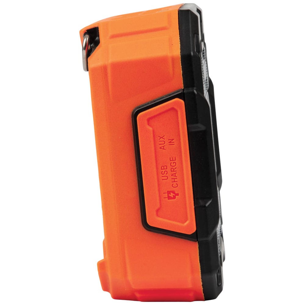 Side profile of the Klein Tools AEPJS3 portable power bank speaker showing the rubberized cover protecting the USB charge-out ports and the AUX-in port.