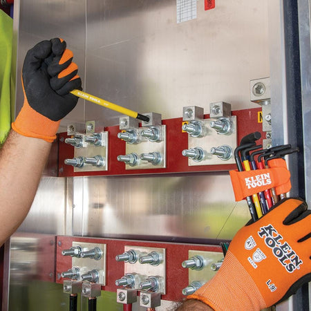 Professional electrician using a color-coded ball end hex key from the BLS18 set to perform maintenance on industrial electrical equipment, showcasing the tool's extended reach.