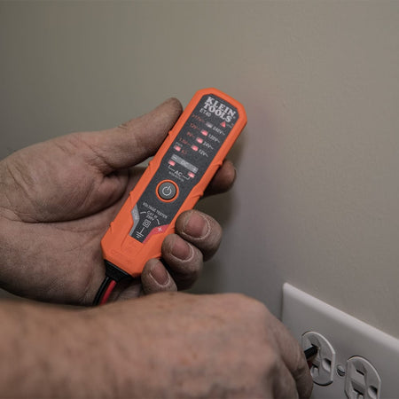 A technician using the ET40 Electronic Voltage Tester to check a standard wall outlet. Multiple red LED indicators are illuminated on the tester's interface, providing a clear visual confirmation of the AC voltage levels present in the circuit.