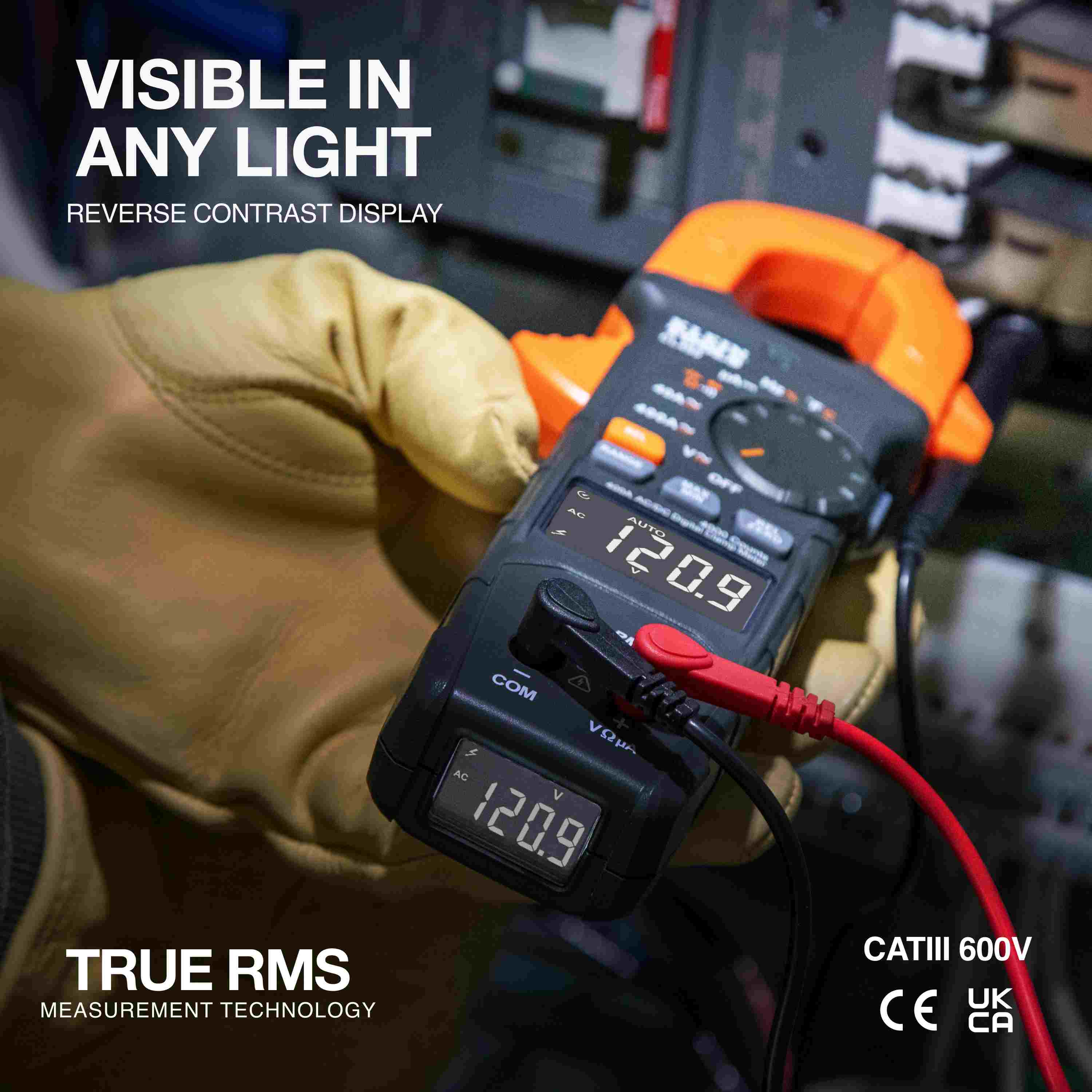A professional wearing gloves using the meter to test an electrical panel, displaying a reading of 120.9 on the bright reverse contrast display with text highlighting True RMS Measurement Technology.