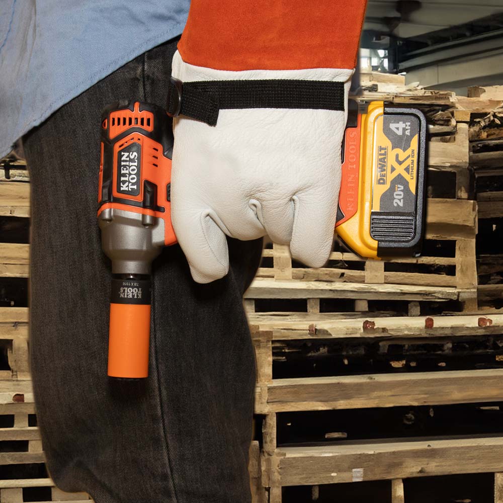 Lineman carrying a cordless impact wrench fitted with an orange Klein 7/8 x 11/16-inch coated coaxial socket.