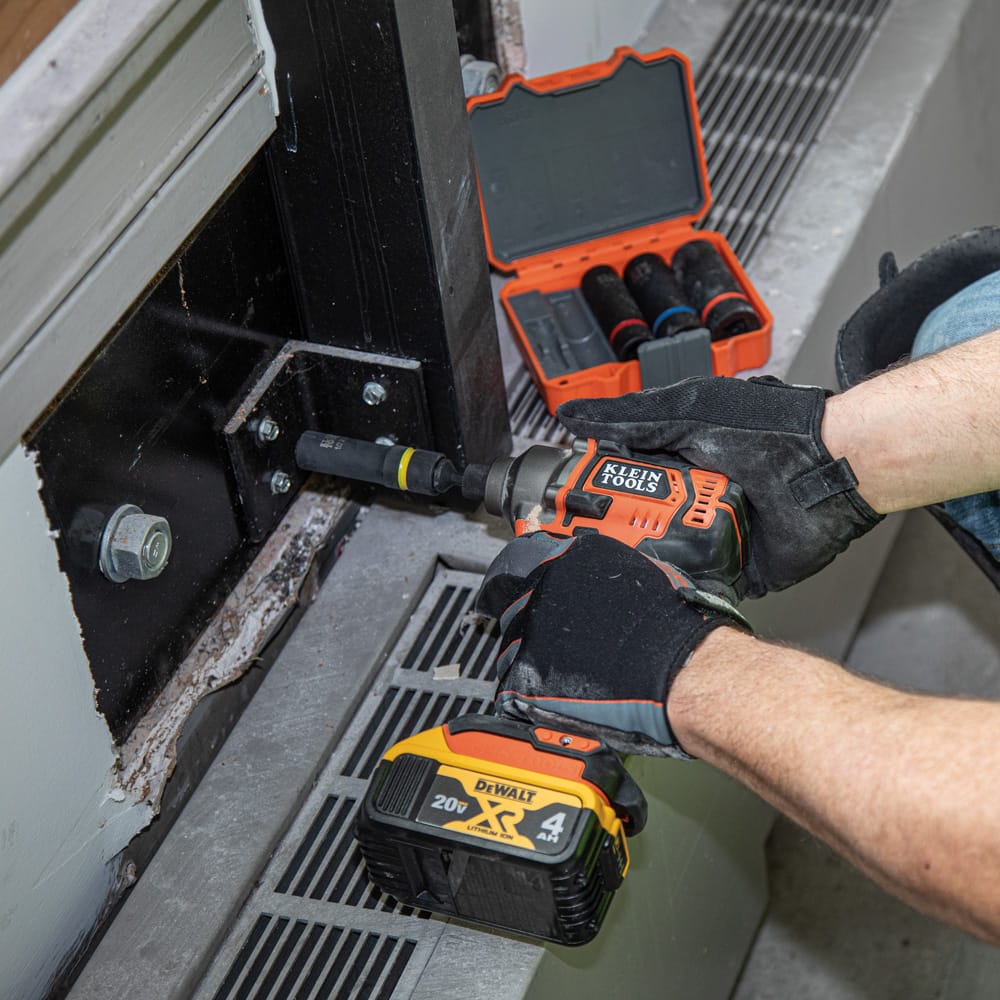 Technician driving mounting bolts on structural steel framing using a Klein 12-point coaxial socket mounted on a 1/2-inch impact wrench.