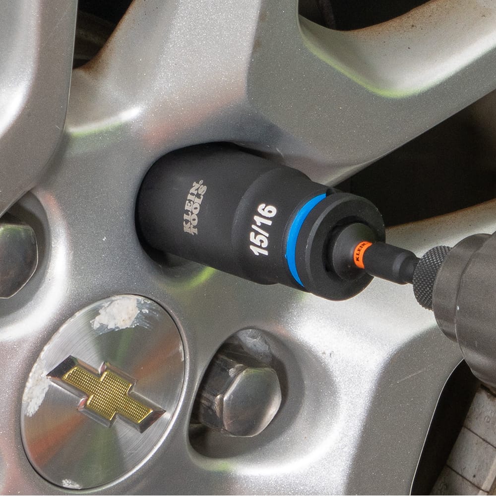 Mechanic using an impact driver with a Klein 15/16-inch deep-well socket to torque a lug nut on a automotive wheel assembly.