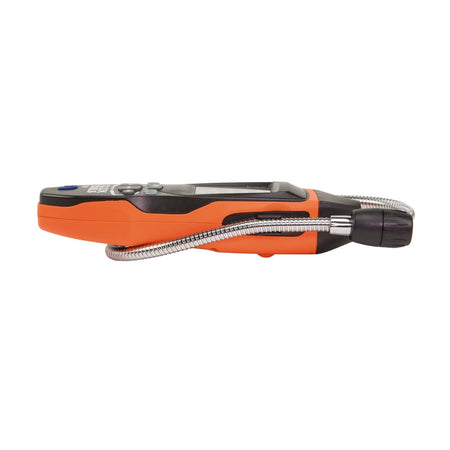A technician using the Klein Tools ET120 to probe for gas leaks along a yellow corrugated stainless steel tubing (CSST) line. The flexible gooseneck is bent to position the sensor tip precisely at the connection point, illustrating the tool's versatility.