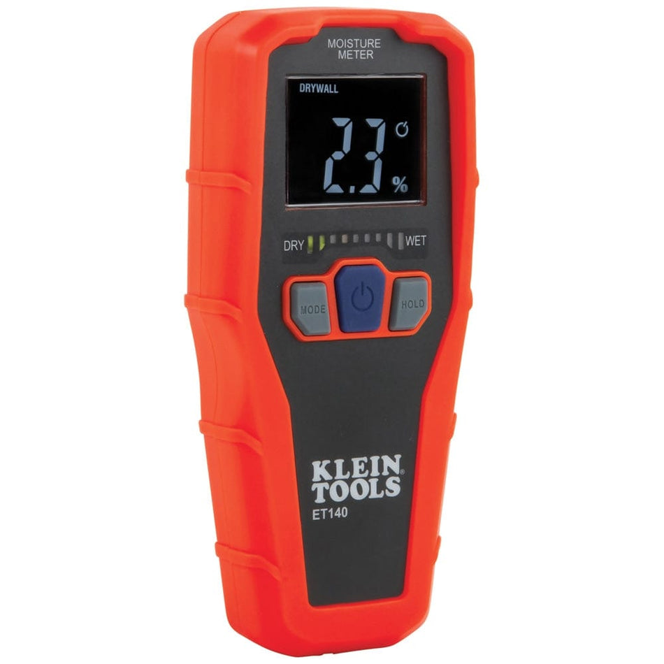 A studio shot of the Klein Tools ET140 Pinless Moisture Meter against a white background. The device features a bright orange housing with a black faceplate, a digital LCD screen showing a 2.3 percent moisture reading, and three buttons for mode selection, power, and data hold.