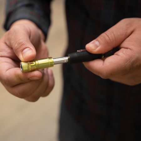 Technician sliding the yellow protective collar forward on a Klein 32614 driver to conceal the metal bit tip for safe pocket storage.