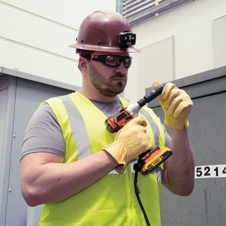 Utility worker checking the Klein 66080 flip socket size orientation on a 1/2-inch impact wrench before opening a pad-mounted electrical enclosure.