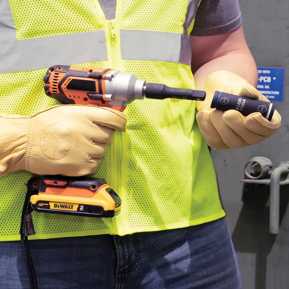 Electrician holding a cordless impact wrench while reversing the Klein 66080 flip socket on its 1/2-inch drive adapter.