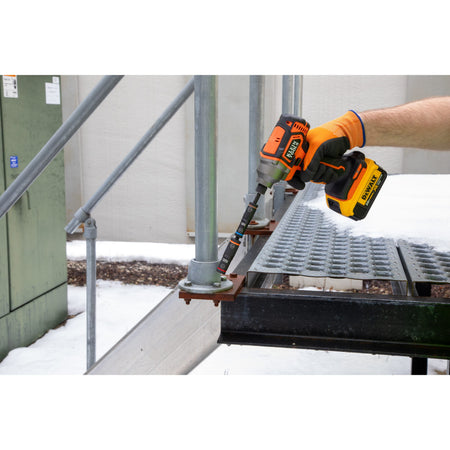 Technician operating an impact driver with two pre-stacked Klein flip sockets to rapidly tighten outdoor handrail flange bolts.