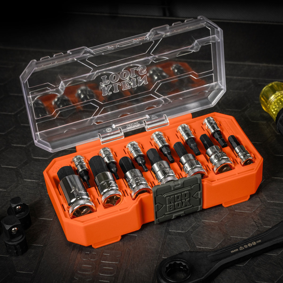 Klein 65213HEXM set open on a jobsite workbench alongside a Cushion-Grip handle and pass-through wrench for flexible driving options.