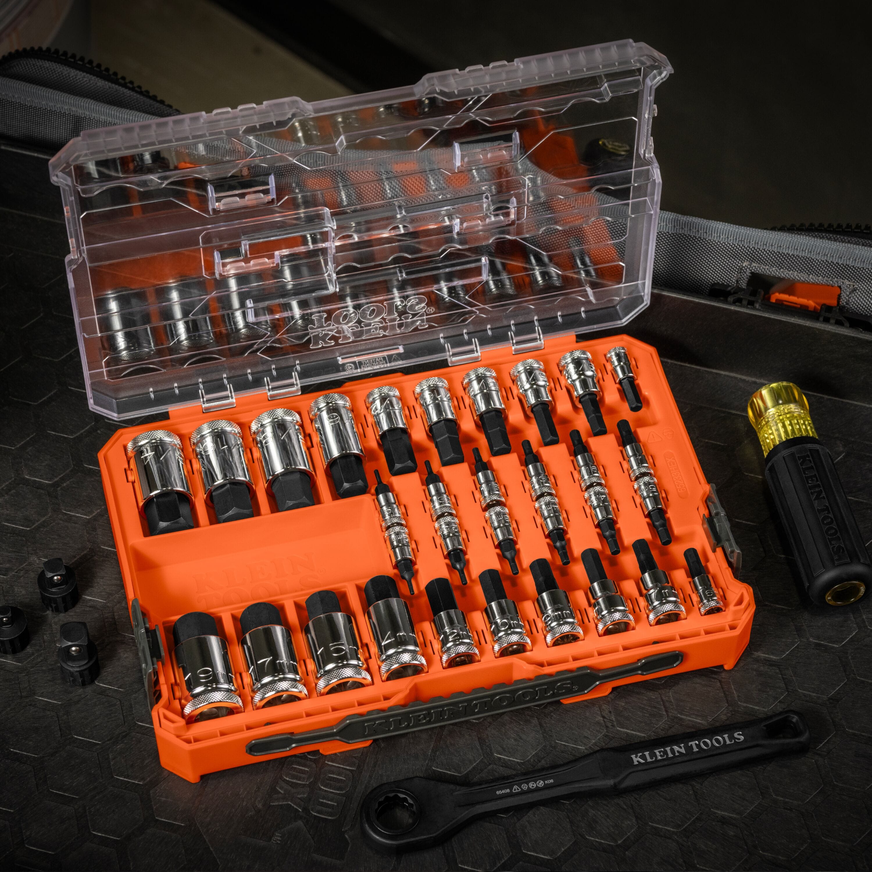 Klein 65233HEX 32-piece set opened on a jobsite workbench alongside a ratchet and screwdriver handle for fast socket identification.
