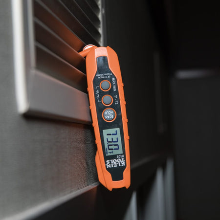 Action shot of the non-contact IR sensor measuring the surface temperature of industrial mechanical equipment. The red targeting laser helps the user identify the exact measurement area, while the ergonomic grip allows for steady, one-handed operation.