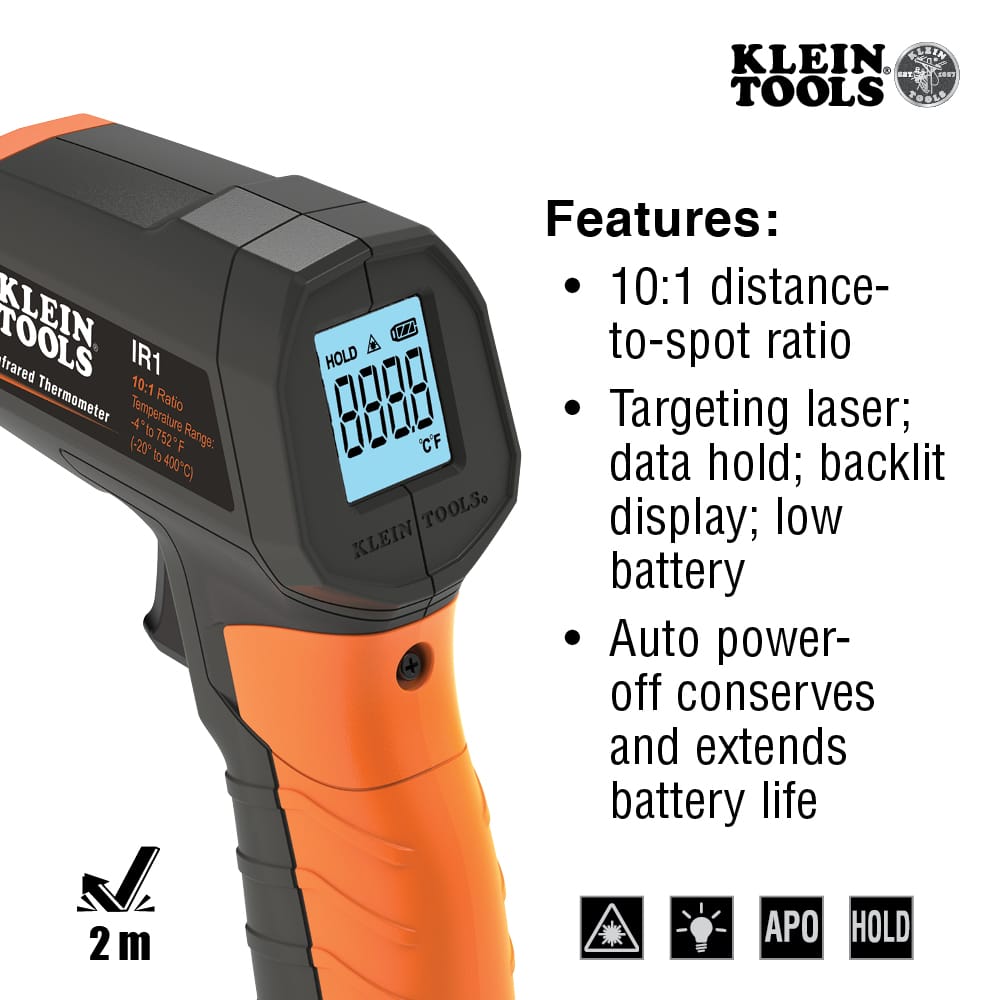 Action shot of the Klein Tools IR1 infrared thermometer being used to measure the temperature of an electrical panel. The targeting laser is shown pinpointing a specific terminal block, demonstrating its utility in detecting hot spots and identifying potential electrical failures from a safe distance.