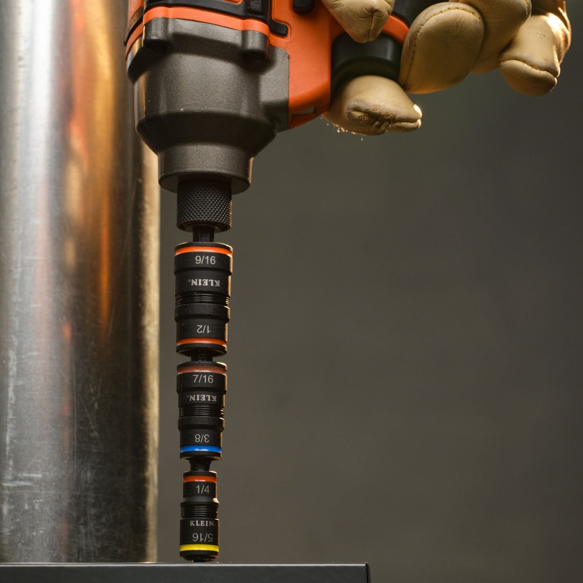 Technician driving hex head fasteners using the Klein 32303HD flip socket attachment locked into a cordless impact driver.
