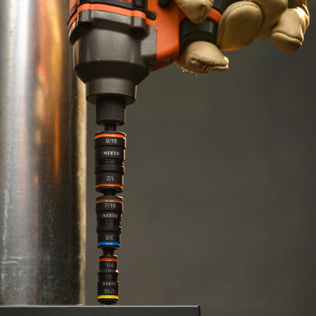 Technician driving hex head fasteners using the Klein 32303HD flip socket attachment locked into a cordless impact driver.
