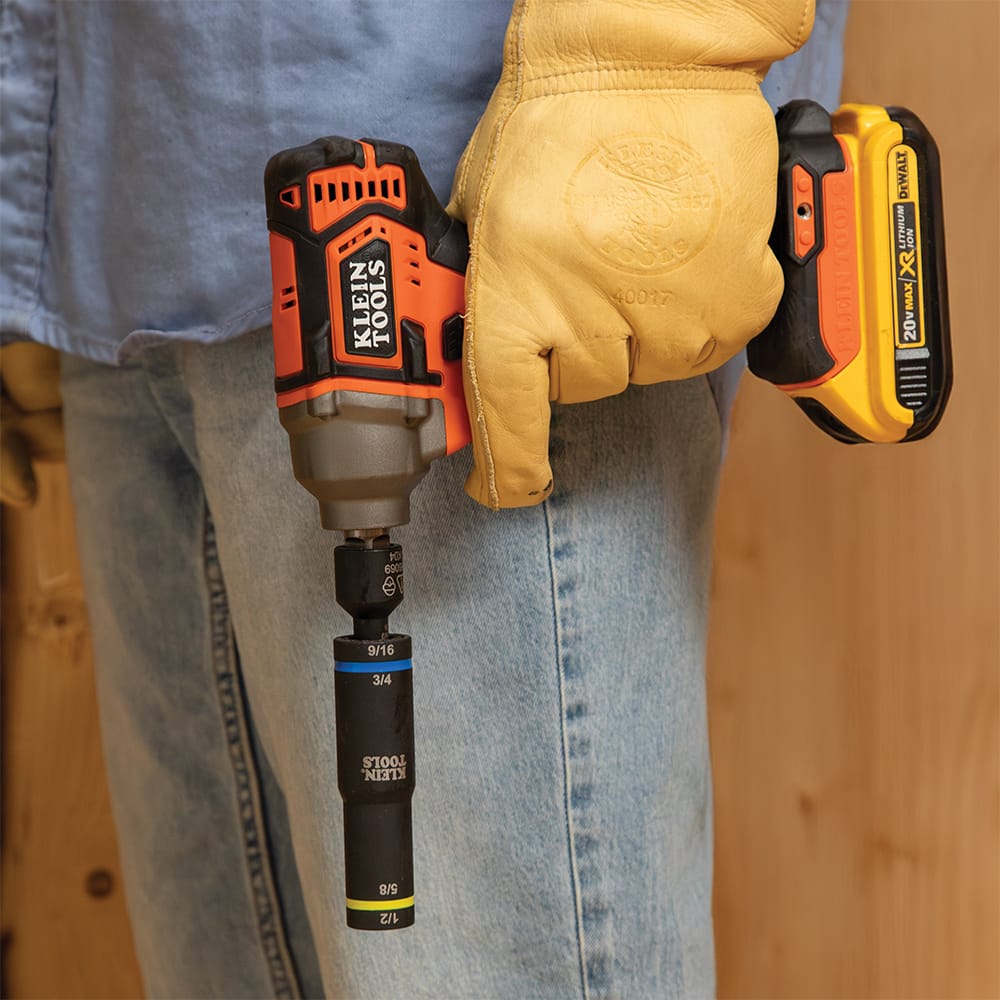 Gloved technician carrying a cordless impact driver fitted with a Klein 66009 quad flip socket for quick overhead fastener installation.