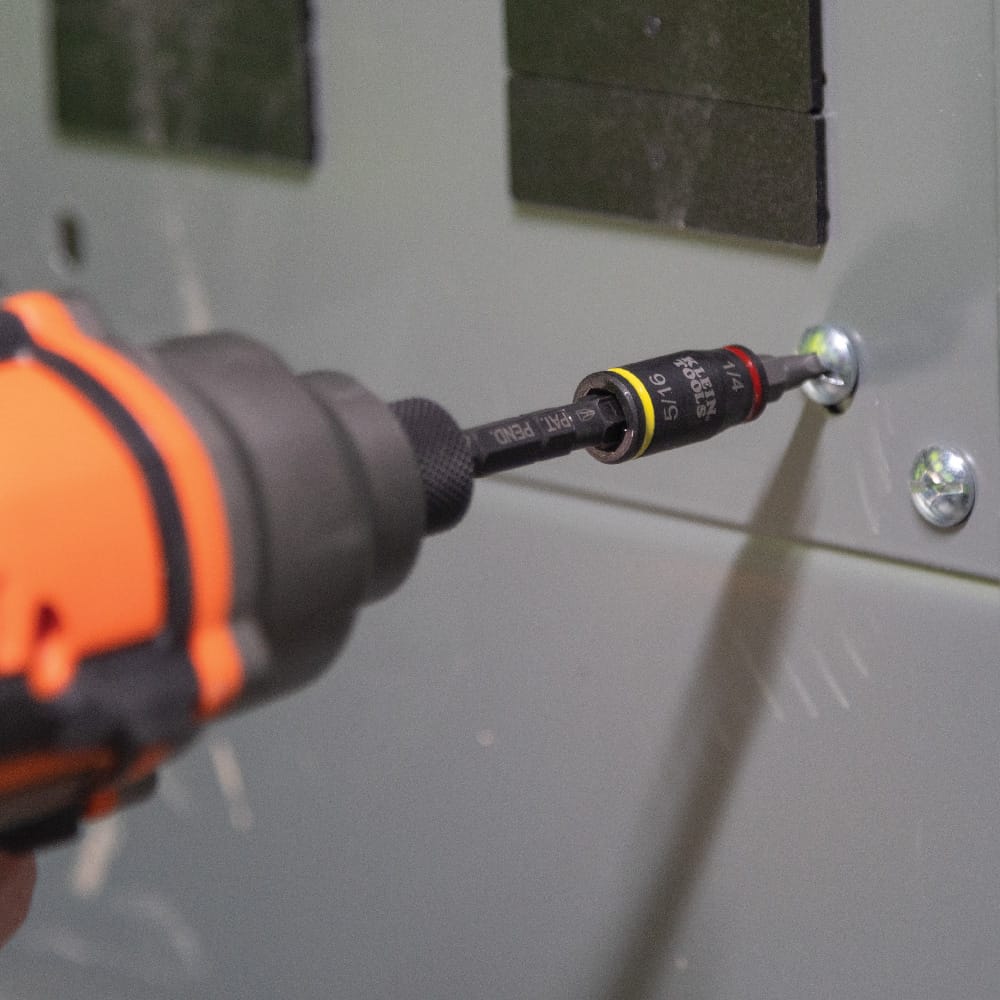 Power impact driver operating the 32766 magnetic extension bit holder to fast-drive panel screws during electrical cabinet assembly.