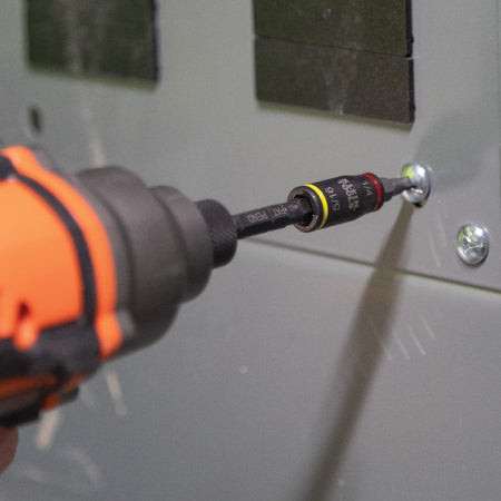 Power impact driver operating the 32766 magnetic extension bit holder to fast-drive panel screws during electrical cabinet assembly.