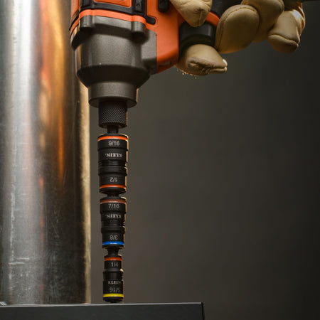 Technician driving sheet metal screws on an HVAC duct using the Klein 32910RCHT flip socket extension set mounted in a power impact driver.