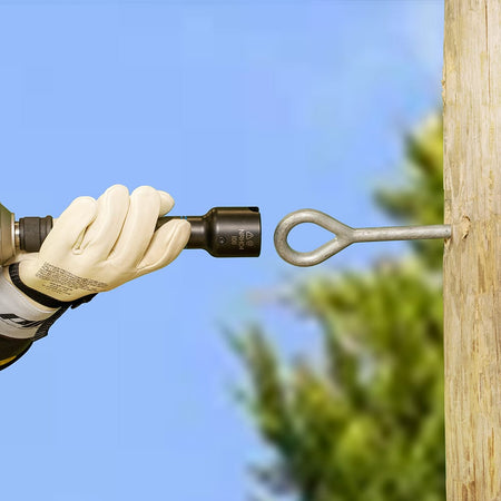 Lineman aligning the Klein NRHD4 6-in-1 socket with utility pole eyelet hardware during aerial line framing.