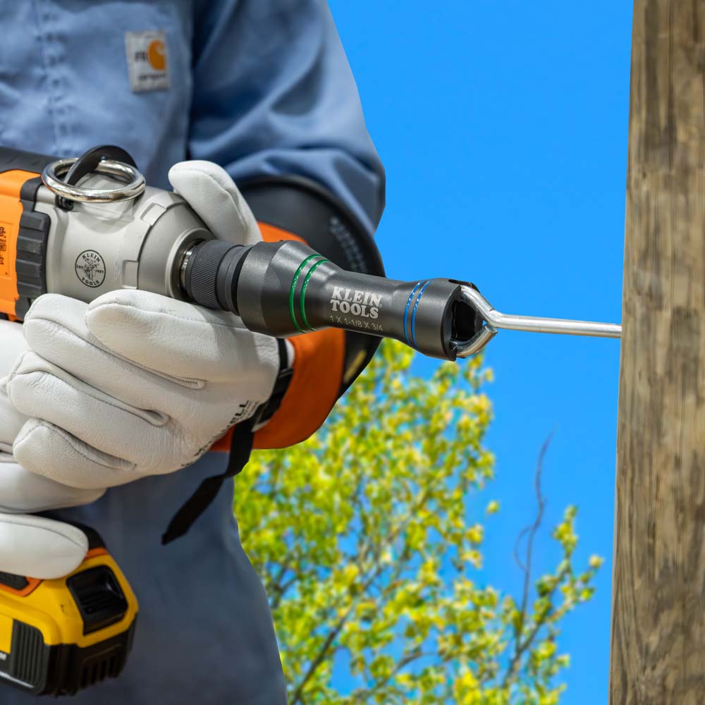 Lineman torquing a curved utility drive hook into a power pole using the narrow alignment slot on the Klein NRHDM socket.