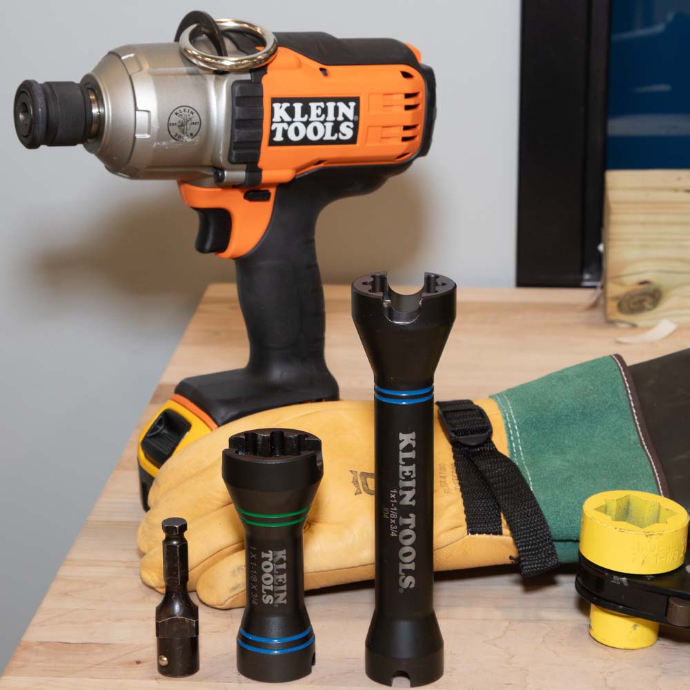 Klein NRHDM mini socket shown beside the standard-length NRHD socket, 7/16-inch adapter, and utility lineman impact gun.