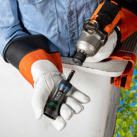 Lineman holding the compact 1.36-lb Klein NRHDM socket in insulated gloves for rapid tool swaps in an aerial bucket.