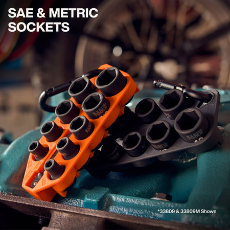 Orange SAE and black metric Klein Grab-And-Go impact socket holders resting on industrial machinery to demonstrate organized storage.