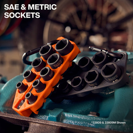 Orange SAE and black metric Klein Grab-And-Go impact socket holders resting on industrial machinery to demonstrate organized jobsite storage.