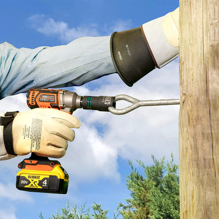 Electrician using a slotted impact socket on a power driver to turn a curved eyebolt on a wooden utility pole aloft.