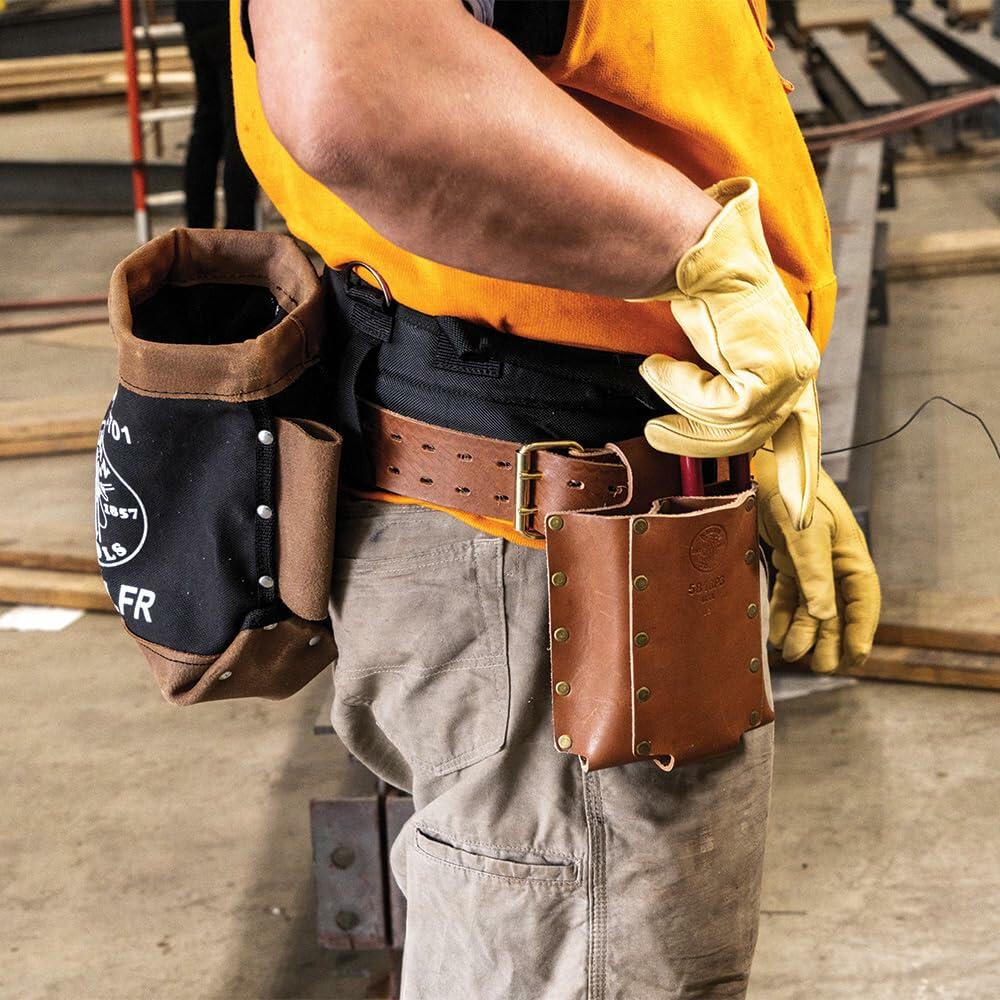 Side view of a worker's waist showing the Klein Tools full-grain leather spud wrench holder next to the flame-resistant canvas bolt bag filled with fasteners and tools.