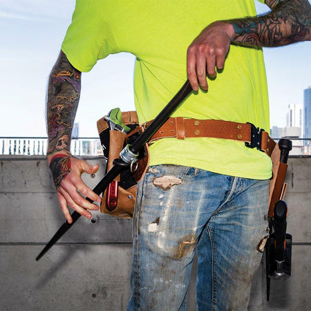 A construction worker wearing the Klein Tools Tool Belt System uses a sleever bar (connecting bar) held in its dedicated leather holder, aligning a steel connection.