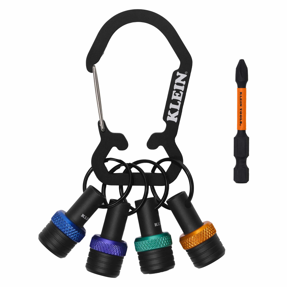 A studio product shot of the Klein Tools K33850 bit holder keychain set, featuring a black heavy-duty carabiner holding four individual aluminum bit organizers with blue, purple, green, and orange identification bands, alongside an included orange and black #2 Phillips driver bit.