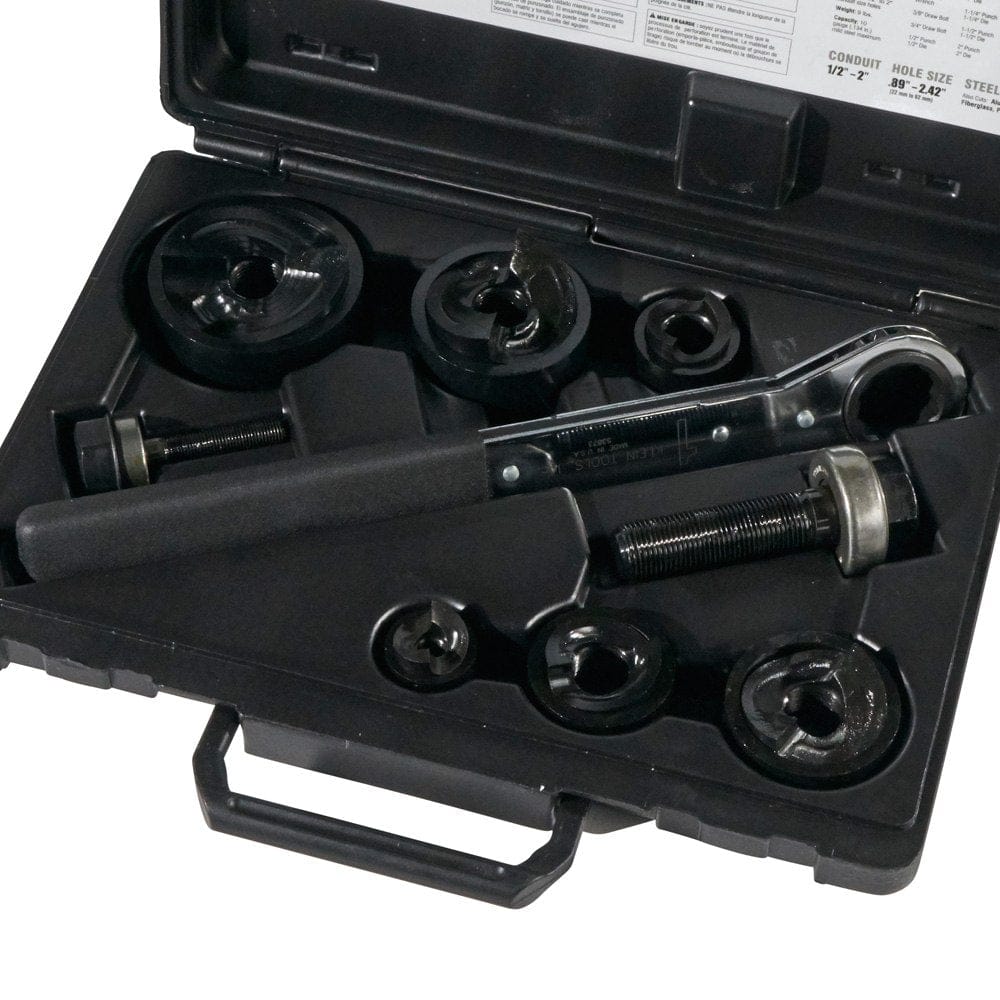 The Klein knockout punch set laid out inside its open black carrying case, showing all punches, dies, studs, and the wrench in their molded spots.
