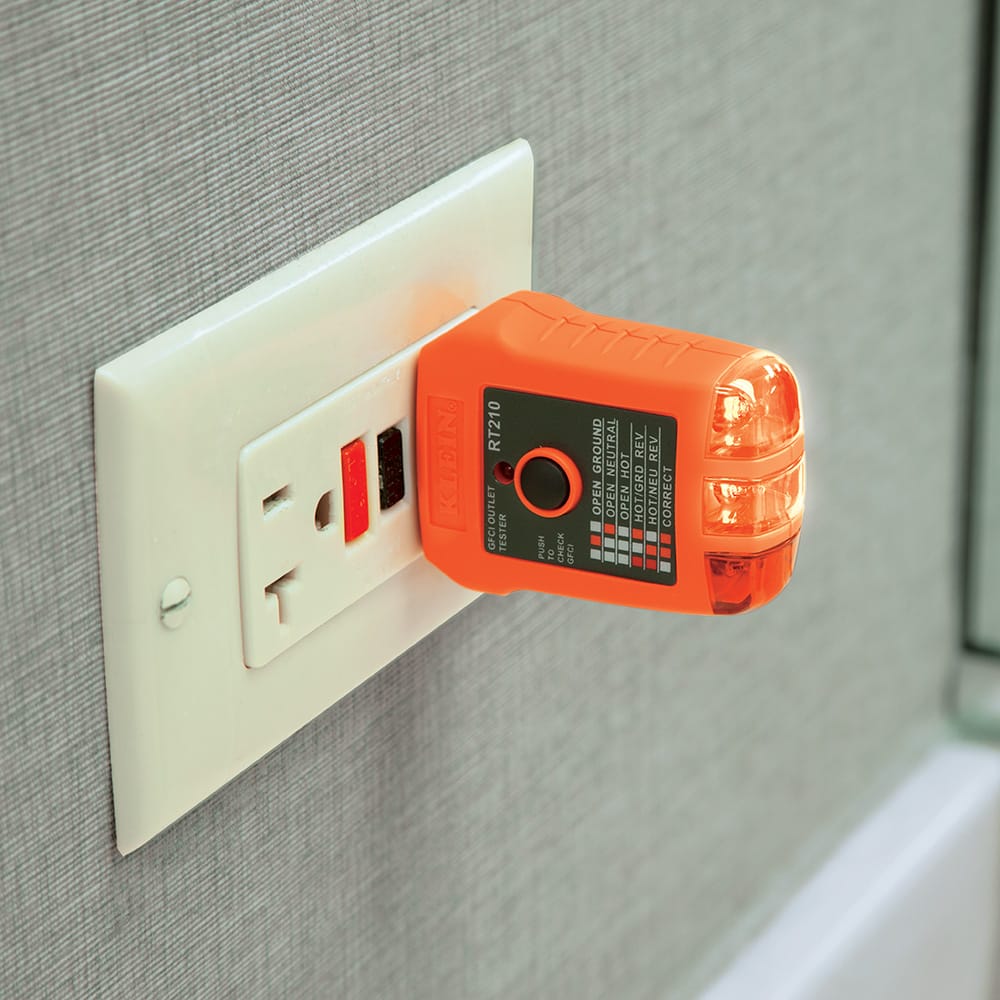 A professional application shot of the RT210 GFCI receptacle tester plugged into a standard wall outlet. The device's bright LED indicators are illuminated to confirm a "Correct" wiring status, demonstrating the tool's ease of use for rapid electrical safety inspections in home and office environments.