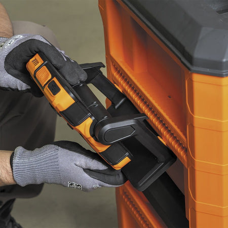 Close-up view of gloved hands sliding the Klein Tools 56417 work light onto the MODbox side rail. This image emphasizes the secure, quick-connect mounting system designed for the MODbox mobile tool storage ecosystem.