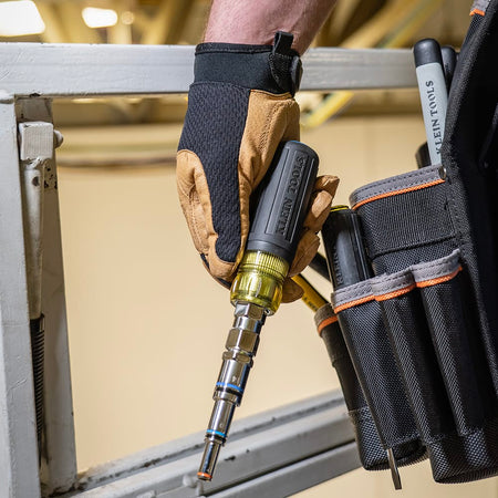 Worker pulling the compact Klein 32809MAGM 11-in-1 metric multi-nut driver from a tool pouch for electrical maintenance.