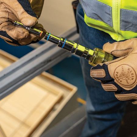 Technician changing nested metric driver barrels on the Klein 32809MAGM to quickly switch hex nut sizes during panel maintenance.